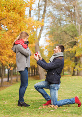Naklejka na ściany i meble smiling couple with engagement ring in gift box