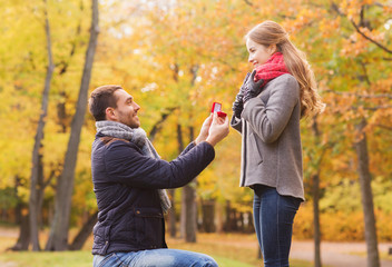 smiling couple with engagement ring in gift box