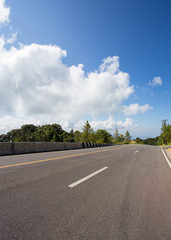 asphalt roadway with cloud blue sky background