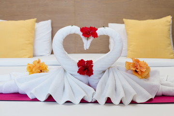 Fototapeta na wymiar white swans made from towels on bed in the hotel