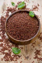 Wooden bowl with red kernel rice, high angle view, studio shot