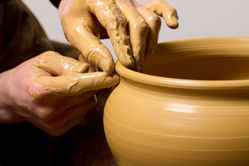 hands of a potter, creating an earthen jar