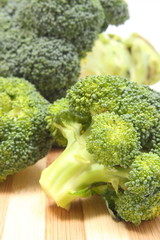 Portion of fresh green broccoli on wooden cutting board