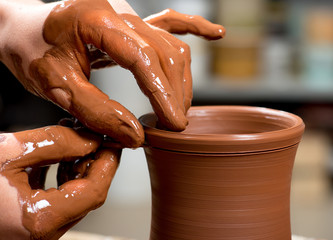 hands of a potter, creating an earthen jar
