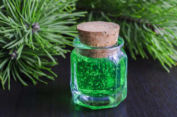 Obraz na płótnie Canvas Small bottle of green gel and pine branches