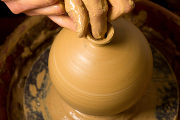 hands of a potter, creating an earthen jar