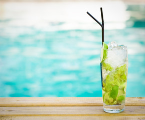 Mohito mojito drink with ice mint and lime near swimming pool