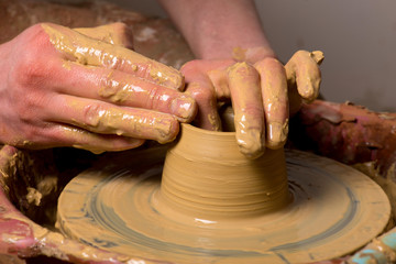 hands of a potter, creating an earthen jar