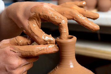 hands of a potter, creating an earthen jar