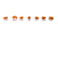 Dried orange colored raisin over white background