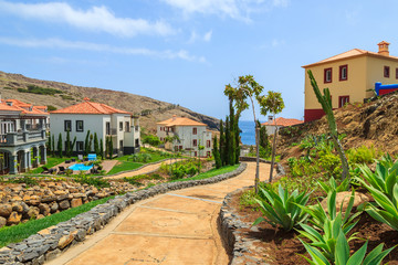 Fototapeta na wymiar Alley in tropical gardens with holiday villas on Madeira island