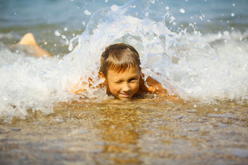 kid in the foam of waves