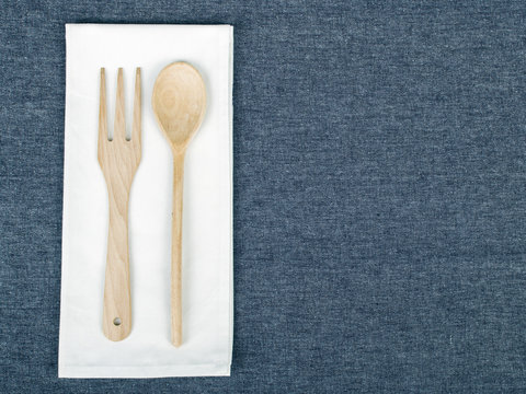 Wooden Spoon And Fork Placed On A White Napkin.