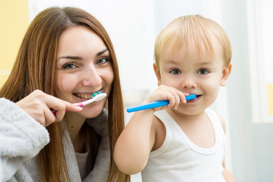 mom and child son brushing teeth in bathroom