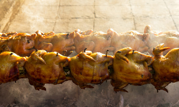 Rotating Spit Roast Chicken On An Charcoal Fire On The Roadside