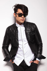 Fashion man leaning on a white wall