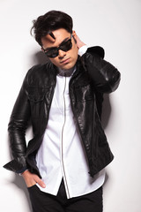 Obraz premium fashion man holding one hand to his neck