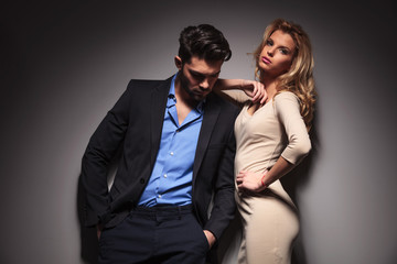 man looking down while his girlfriend is leaning on him