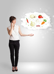 Pretty woman presenting a cloud of healthy nutritional vegetable