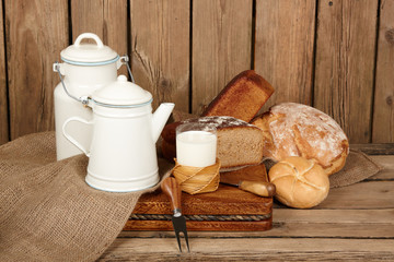 Fresh bread and butter and milk on wooden background