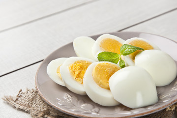 Boiled eggs with mint leaf and white wooden table