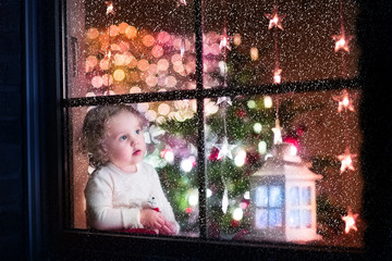 Cute toddler girl during Christmas time, preparing to Xmas Eve