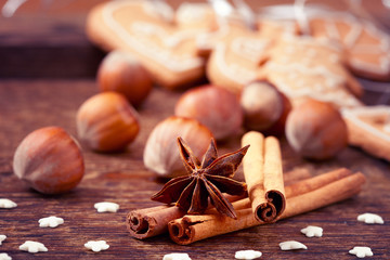 Gingerbread cookies and spices over wooden background.