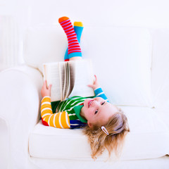 Little cute girl reading a book