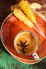 A cup of spiced coffee with anise star and soucers