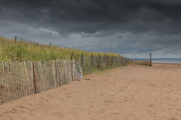 Fototapeta na wymiar Dunes behind a fence