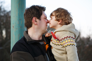 Father and little son in park or forest, outdoors.