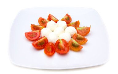 Plate with mozzarella and tomato on white background