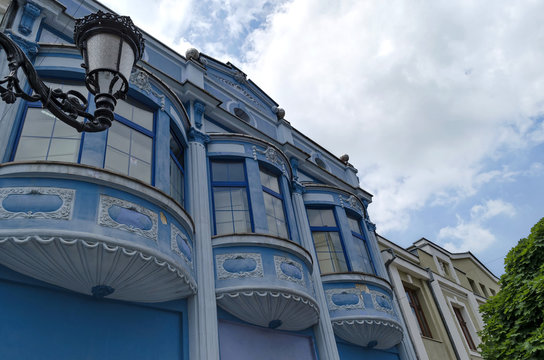 Fragment of old house with bow-window and plaster ornament.