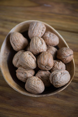 wooden bowl with walnuts on table