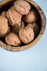 Walnuts in wooden bowl on table