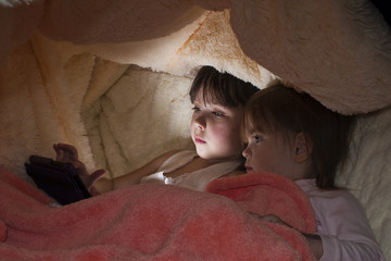 Дети вместо сна играют в планшет под одеялом