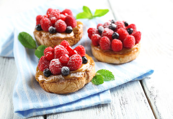 Sweet cakes with berries on table close-up