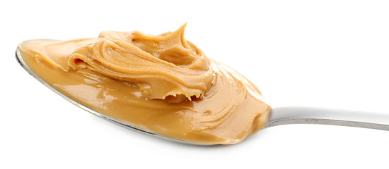 Creamy peanut butter in spoon, isolated on white