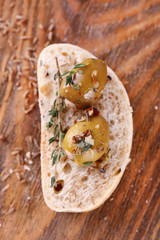 Green olives in oil with spices and bread on table close-up