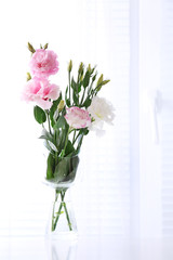 Beautiful flowers in vase with light from window