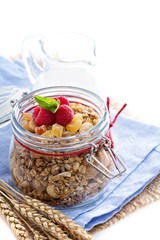 Homemade citrus granola in a glass jar on white