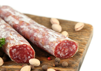 Italian salami on wooden cutting board, isolated on white