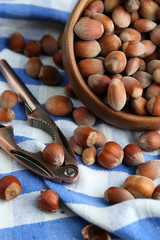 Hazelnuts in wooden bowl, on napkin background