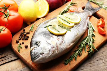 Fresh raw fish and food ingredients on table