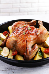 Delicious baked chicken on table on brick wall background