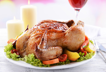 Delicious baked chicken on plate on table on light background