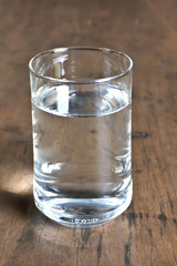 Glass of water on bamboo background.