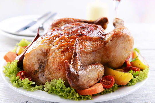 Delicious baked chicken on plate on table on light background