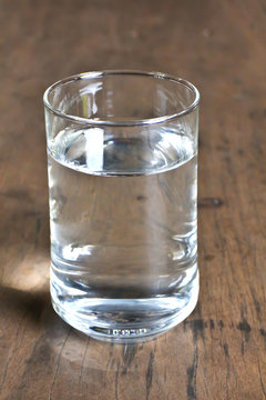 Glass of water on bamboo background.
