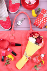 Women bag stuff on wooden background top view